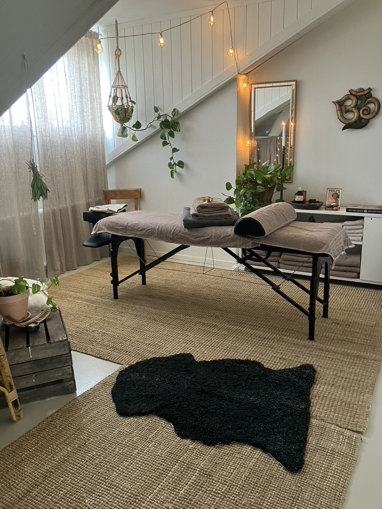 Massagebänk under snedtaket med ljusslinga