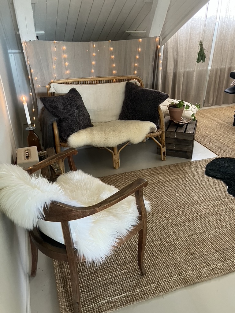 Rottingsoffa med fårskinn och levande ljus